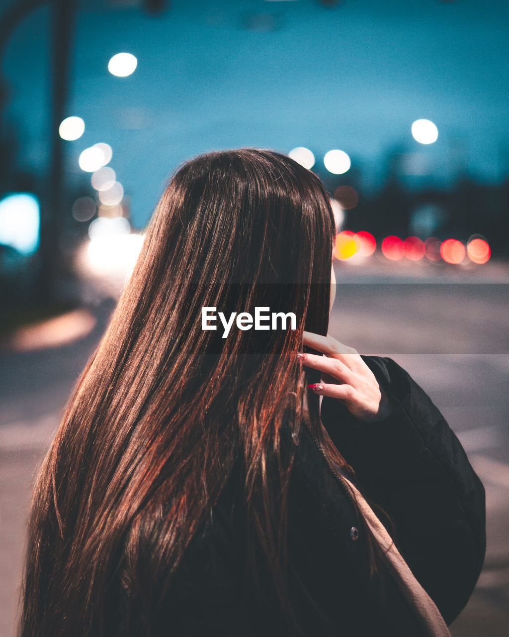 Woman standing in city at night