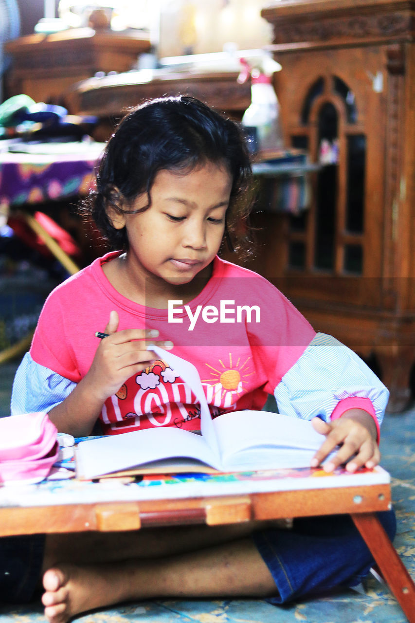 Happy girl sitting on book