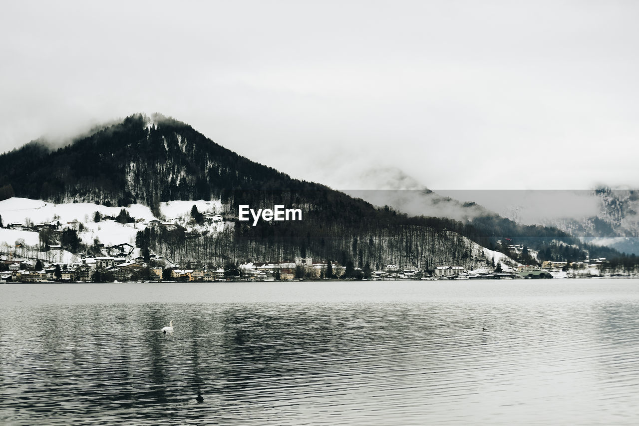 Scenic view of lake by buildings against sky