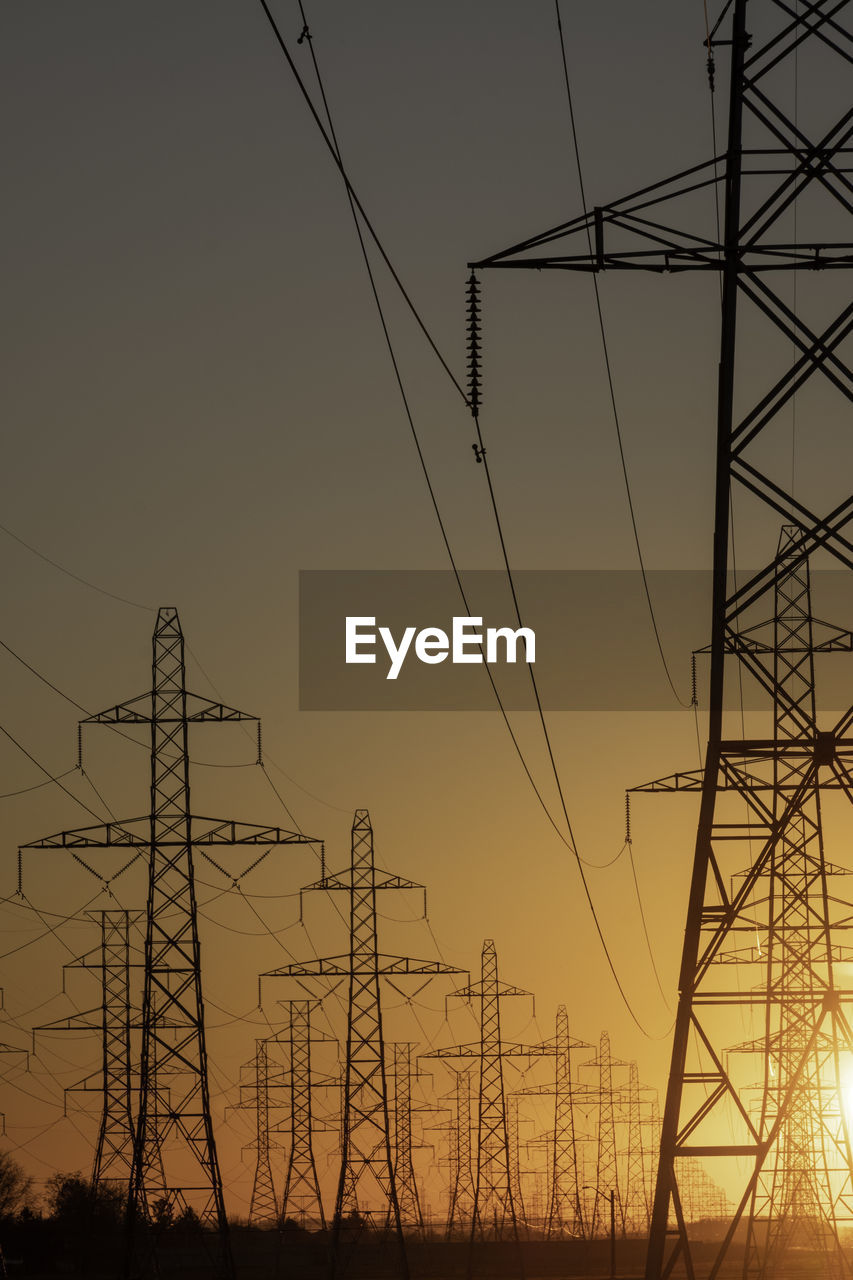 LOW ANGLE VIEW OF ELECTRICITY PYLON AT SUNSET