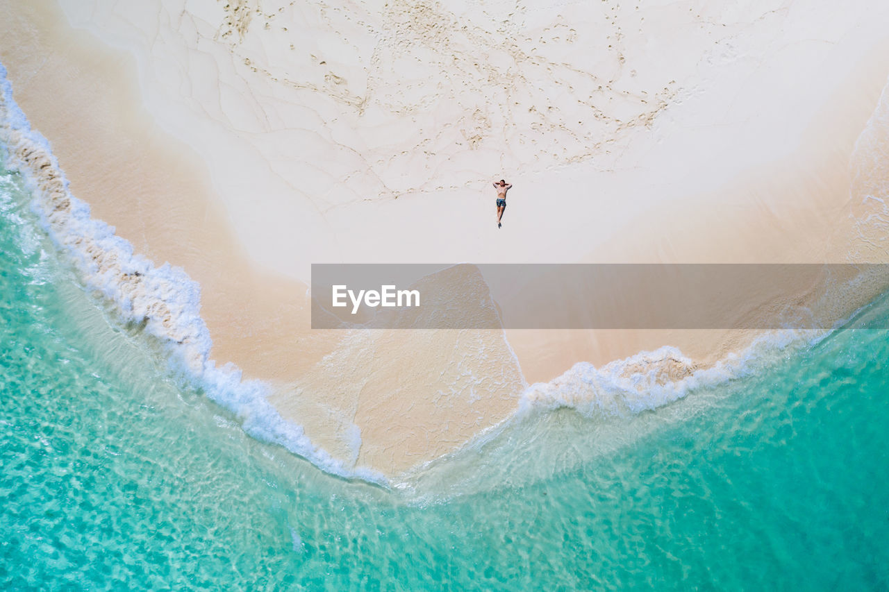 Drone view of man at beach on sunny day