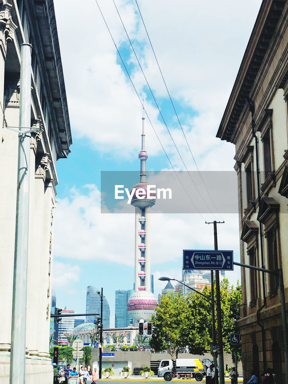 LOW ANGLE VIEW OF COMMUNICATIONS TOWER AGAINST BUILDINGS