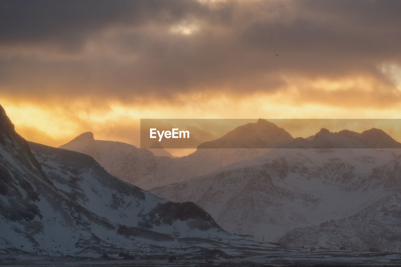 Scenic view of snowcapped mountains against sky during sunset