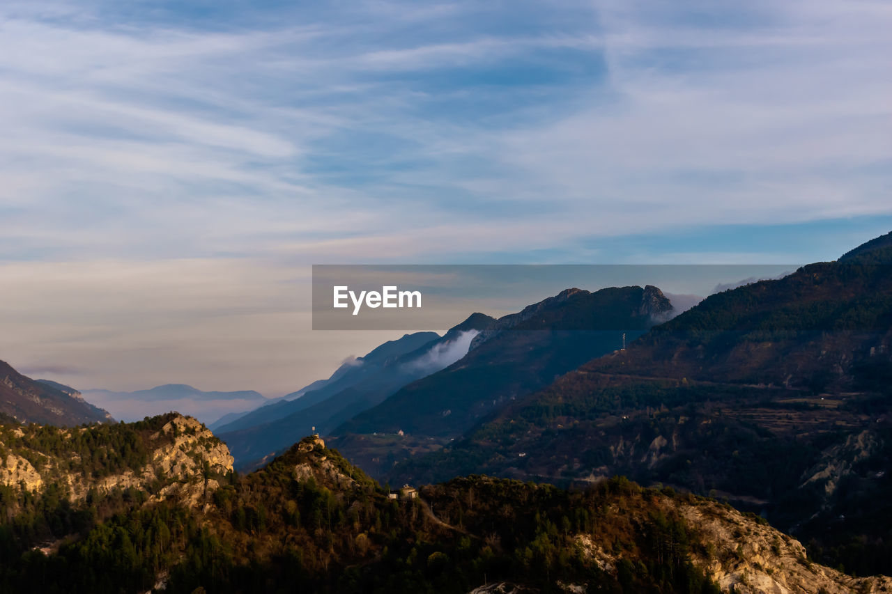 Scenic view of mountains against cloudy sky