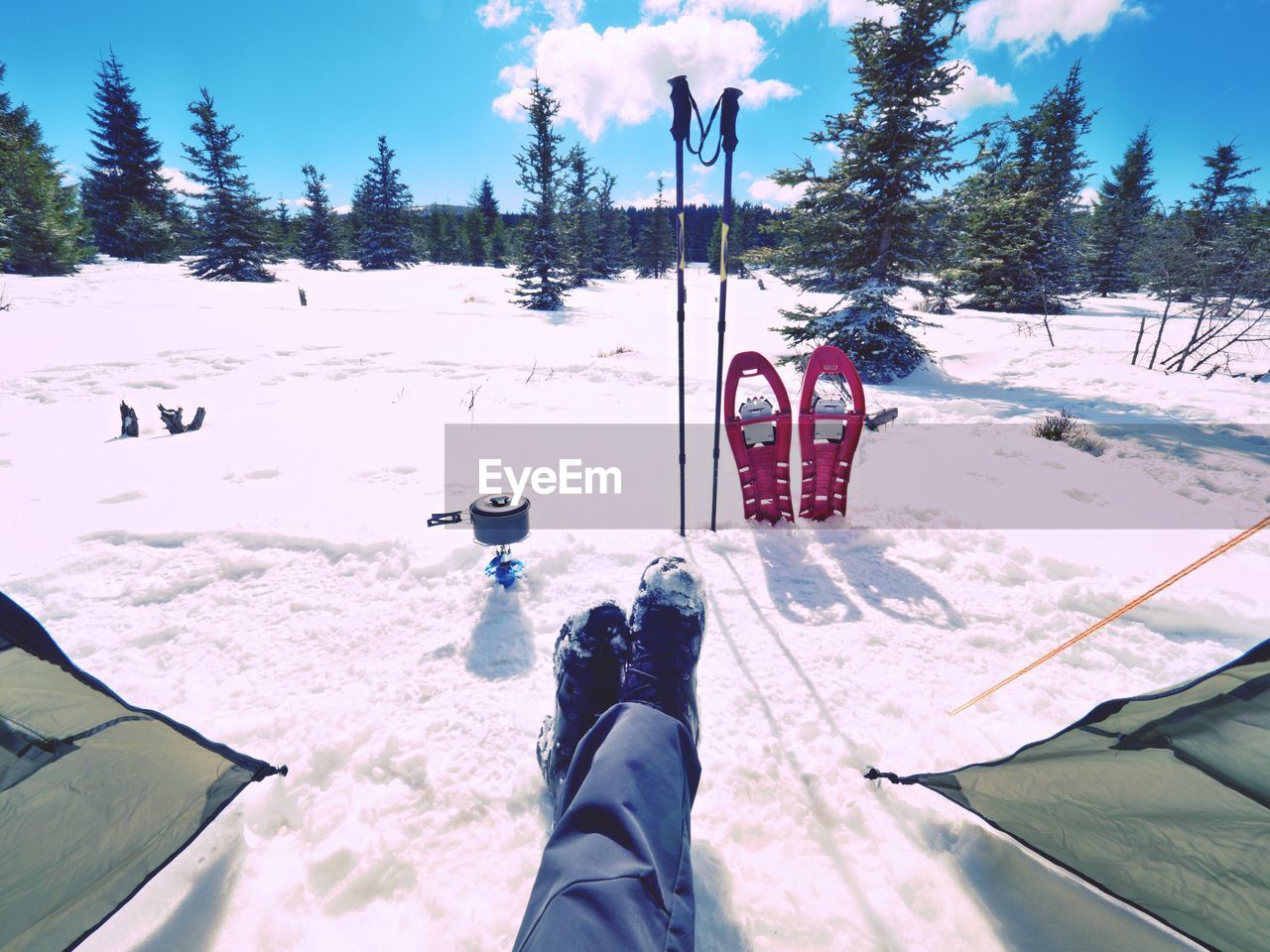 Man relaxing. winter view from camping tent entrance out to snowy landscape. travel lifestyle 