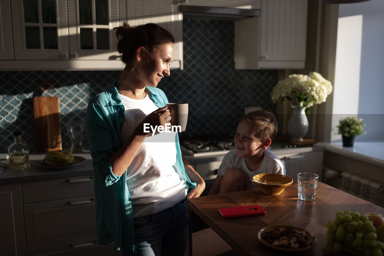 Happy woman and boy having breakfast together