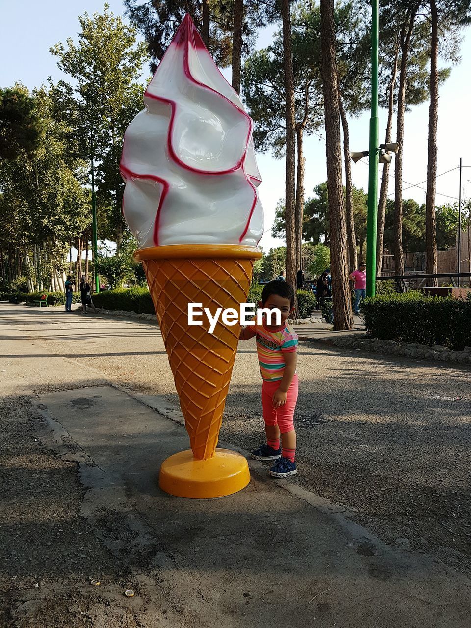 Girl standing by ice cream statue