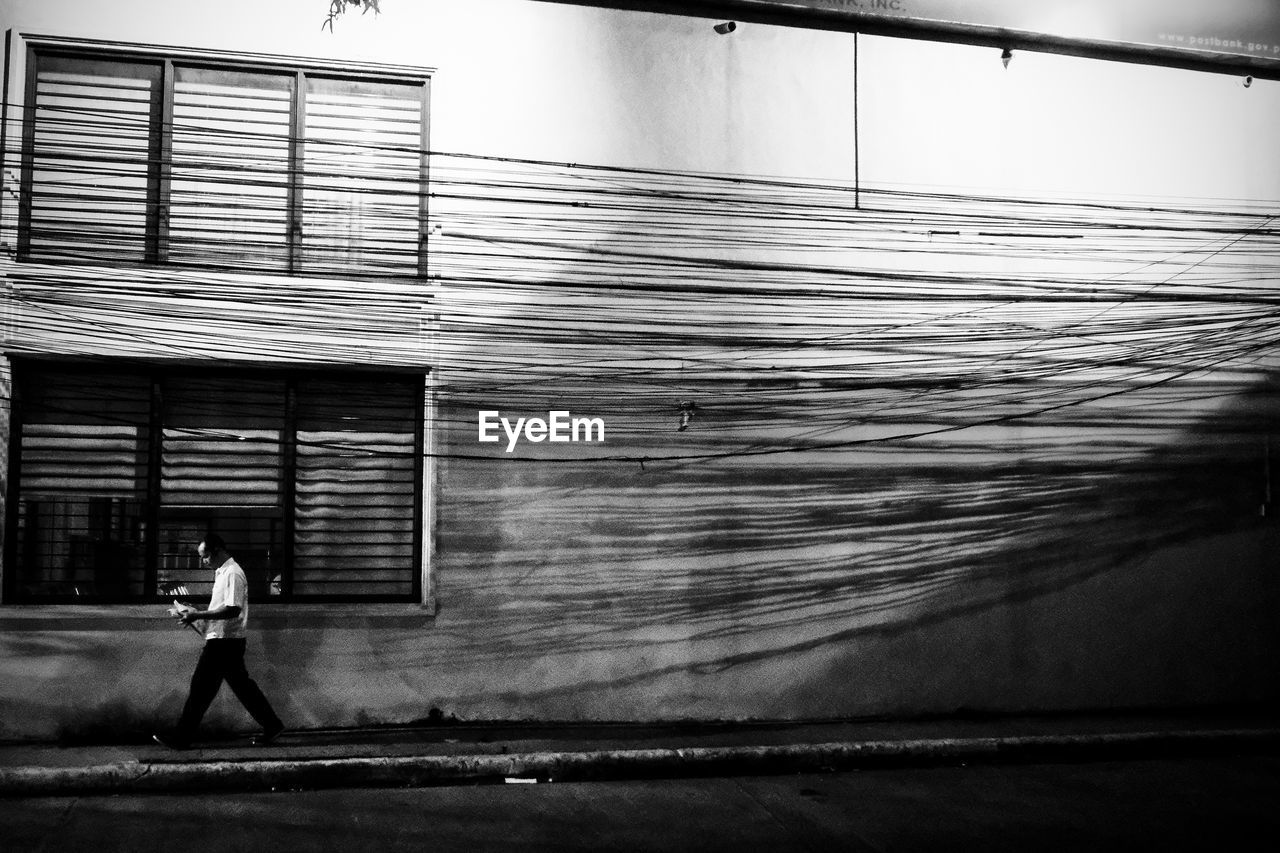 PEOPLE WALKING ON FOOTPATH IN FRONT OF BUILDING