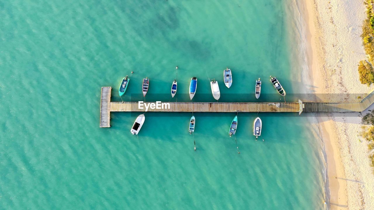 Aerial view of boats moored in sea by pier