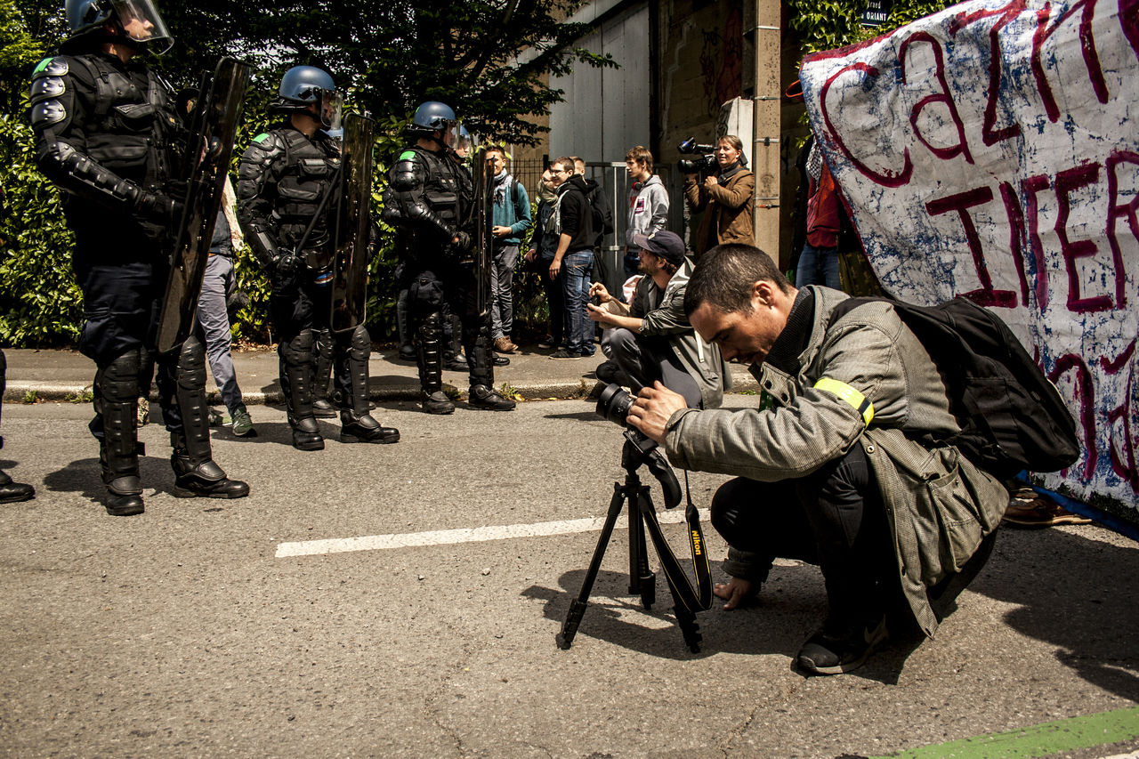 city, protest, crowd, street, person, architecture, men, group of people, government, tripod, clothing, law, adult, day, communication, full length, road, outdoors