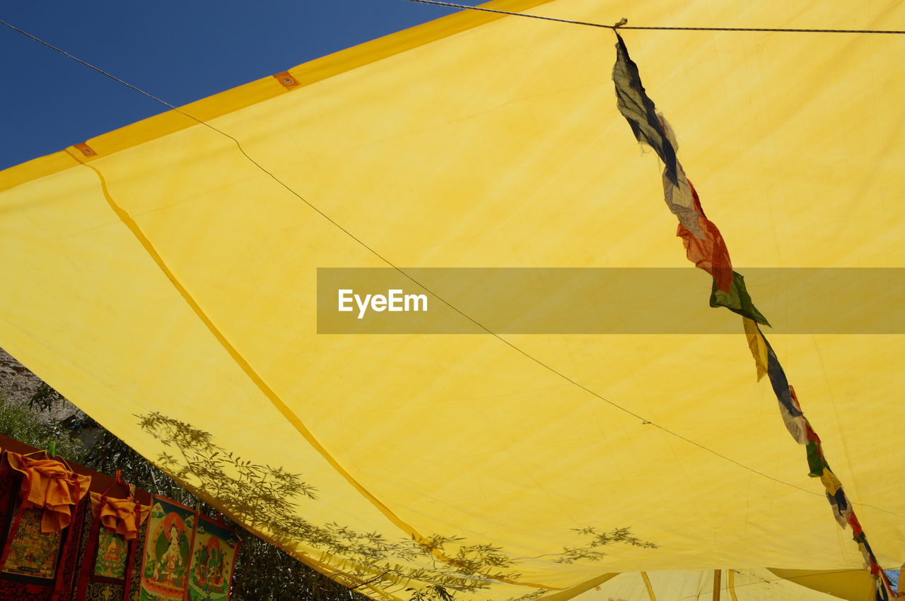 LOW ANGLE VIEW OF YELLOW FLAG AGAINST SKY