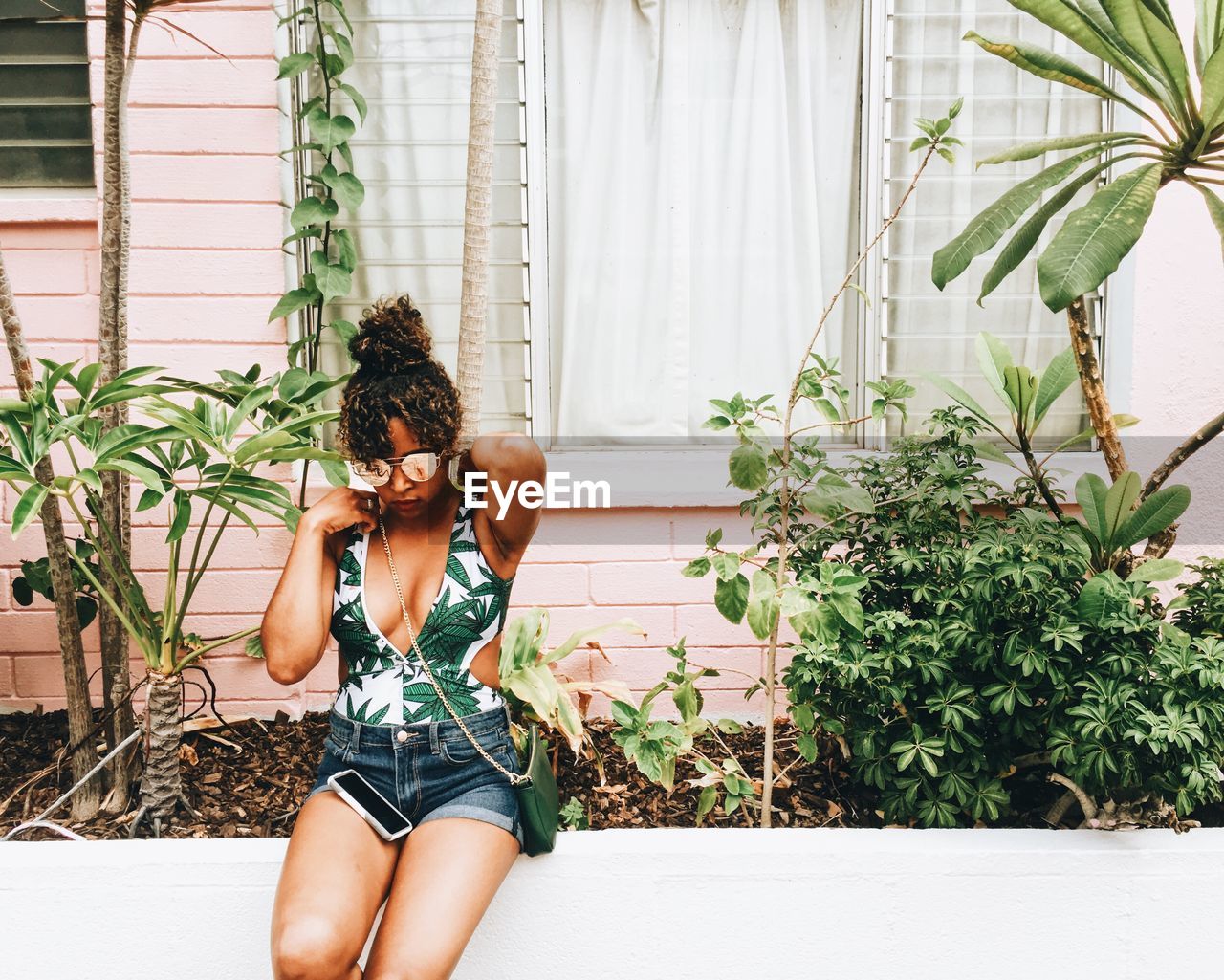 Young woman sitting against house