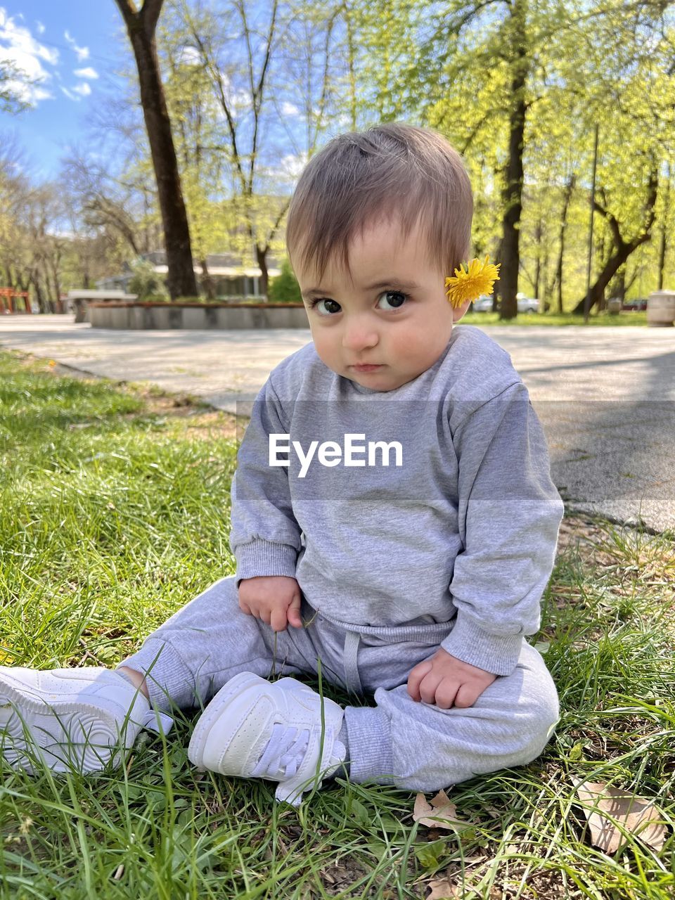 portrait of cute girl sitting on field