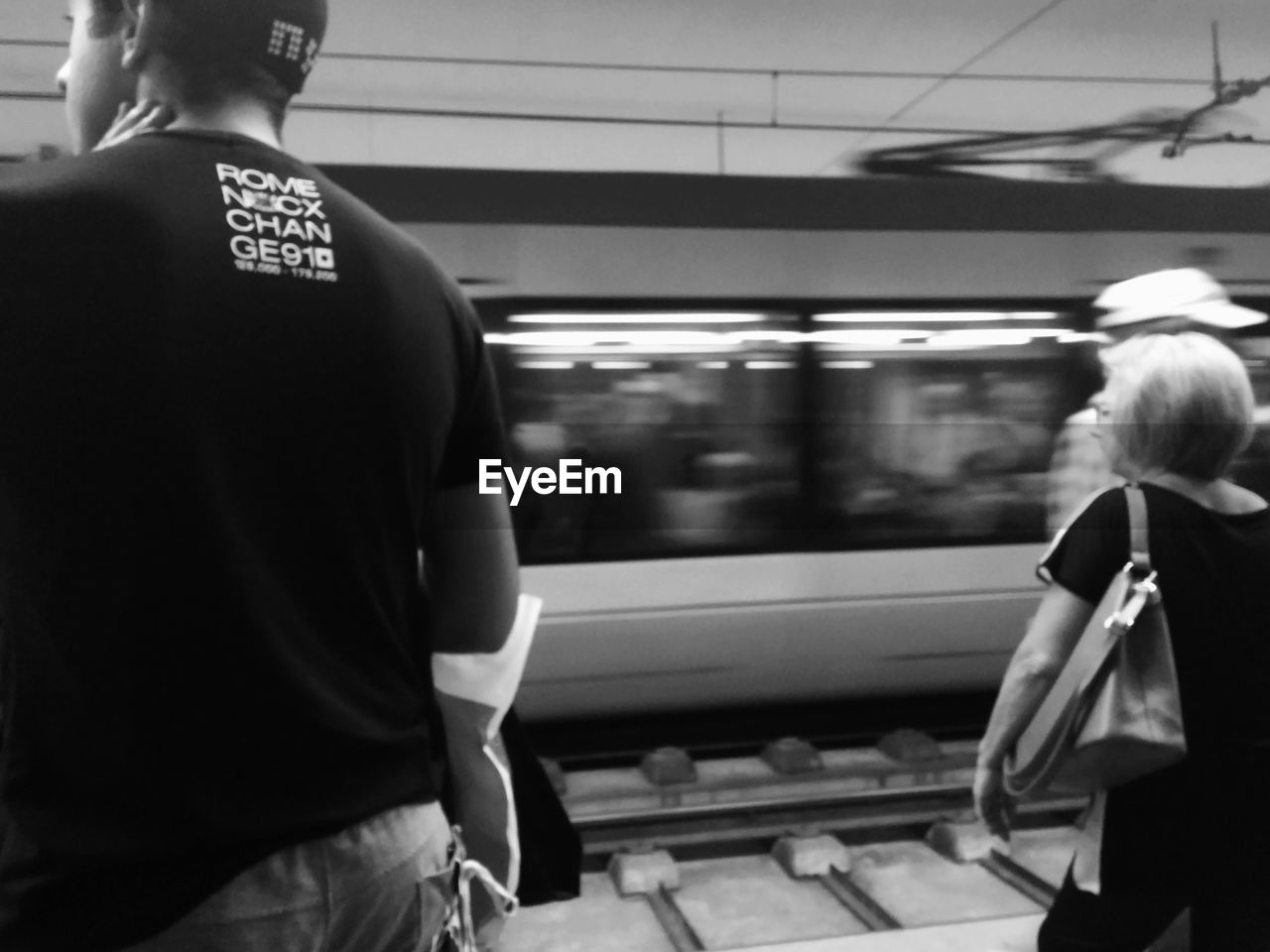 REAR VIEW OF MAN STANDING AT SUBWAY TRAIN