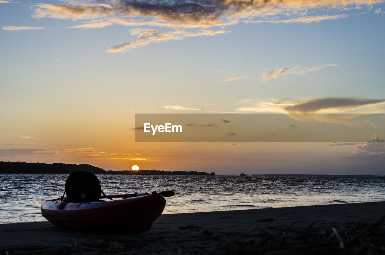 Boat on beach at sunset