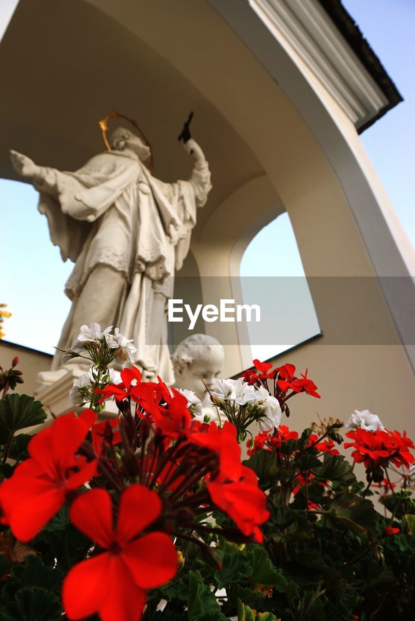 LOW ANGLE VIEW OF STATUE AGAINST WALL