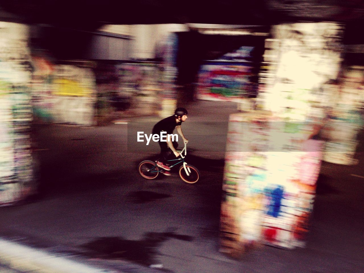 BLURRED MOTION OF WOMAN RIDING BICYCLE