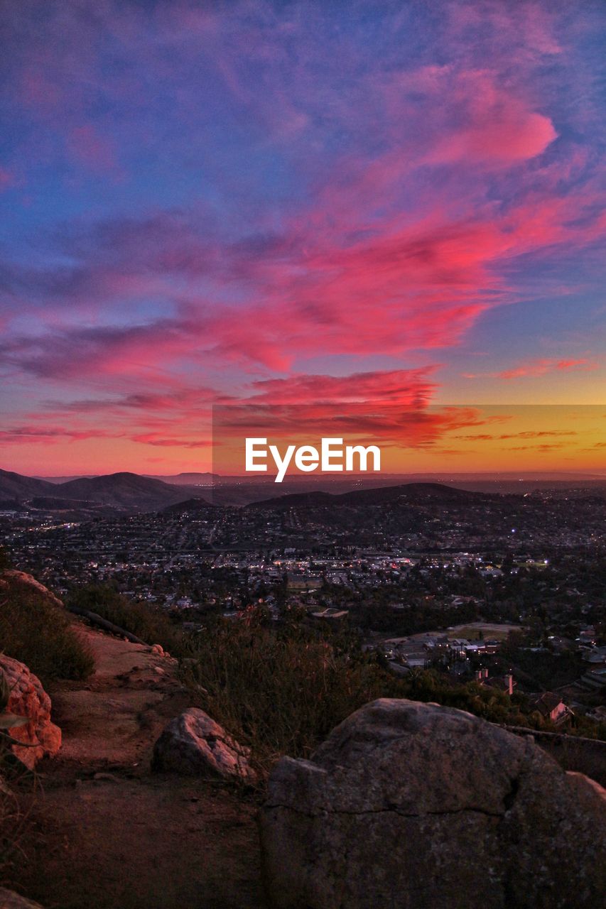 Scenic view of landscape against dramatic sky during sunset