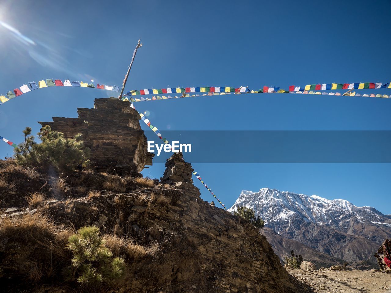 Low angle view of flags on mountain against sky