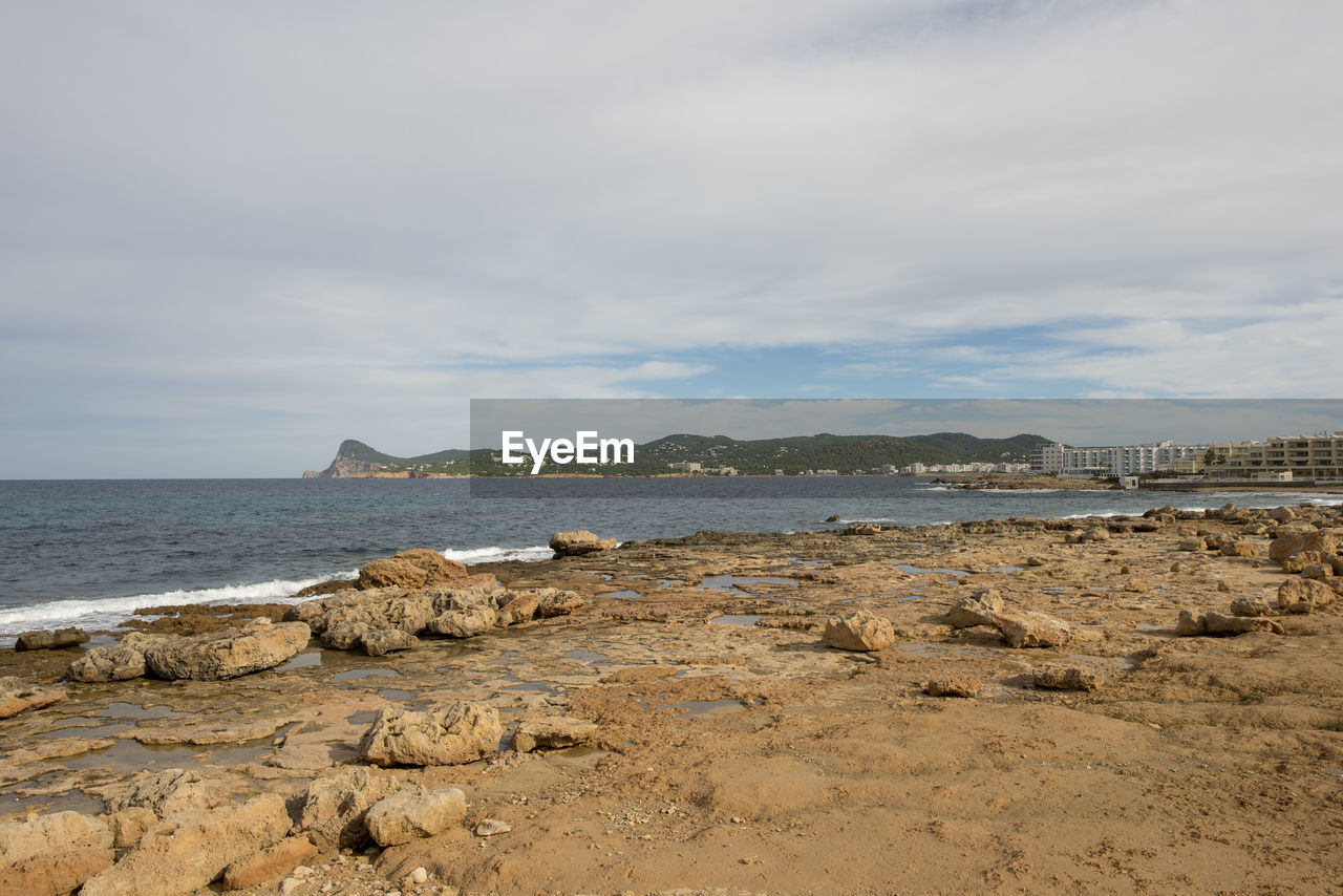 ROCKS ON BEACH AGAINST SKY