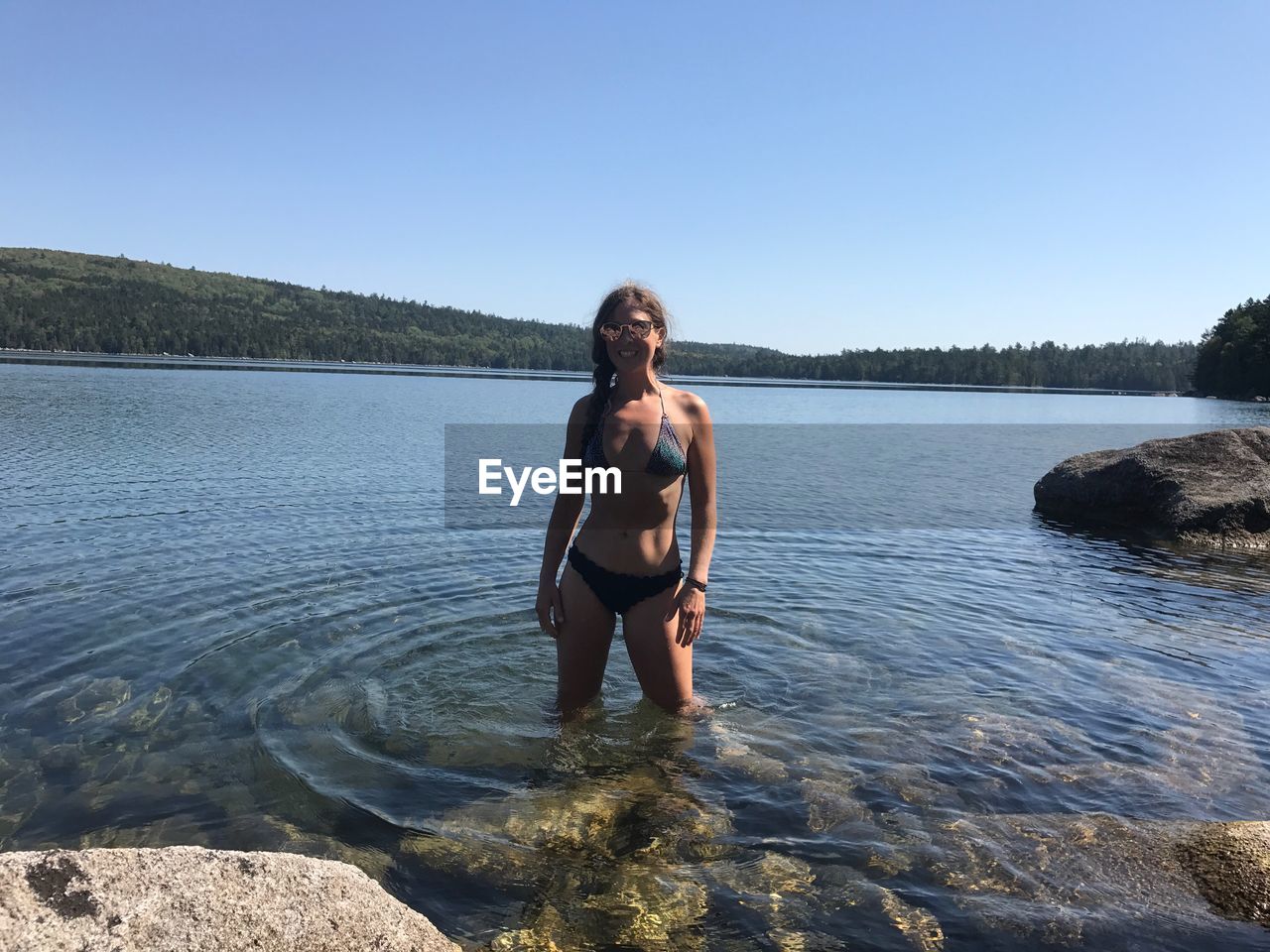 Portrait of sensuous woman standing in lake against sky