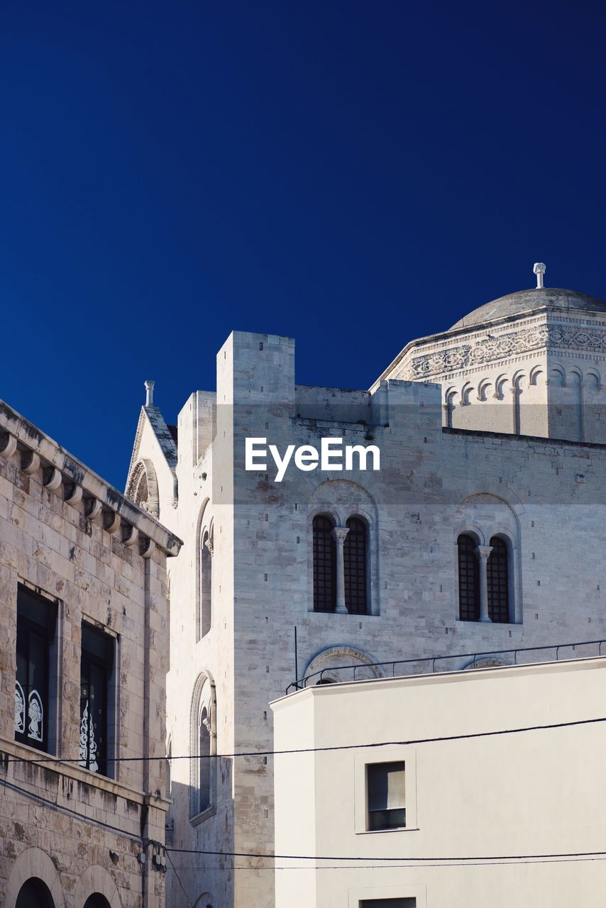 LOW ANGLE VIEW OF BUILT STRUCTURE AGAINST BLUE SKY