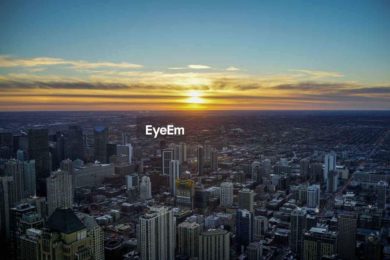 Aerial view of buildings against sky during sunset