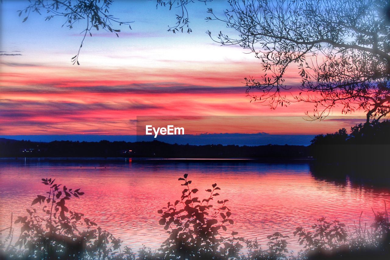 SCENIC VIEW OF LAKE AGAINST ORANGE SKY