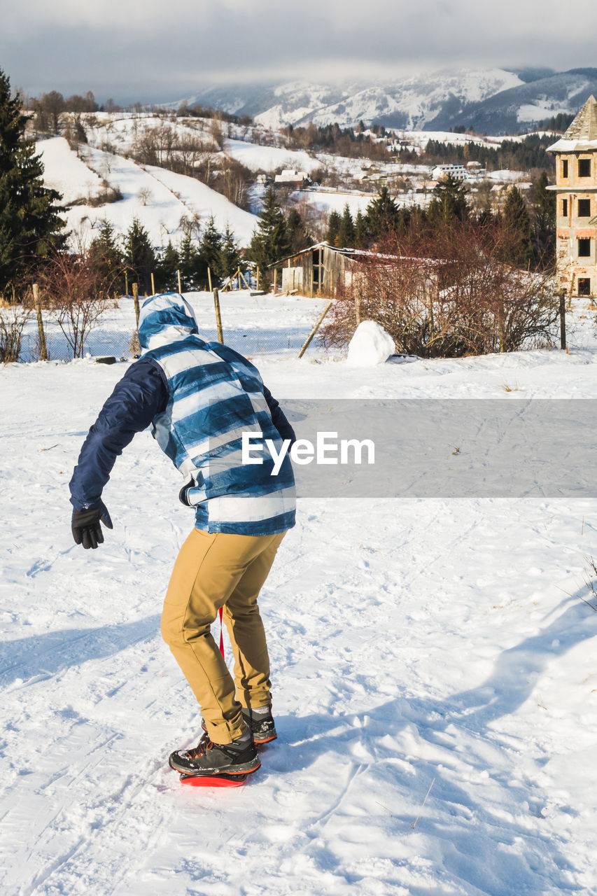 Man learning to snowboard during winter