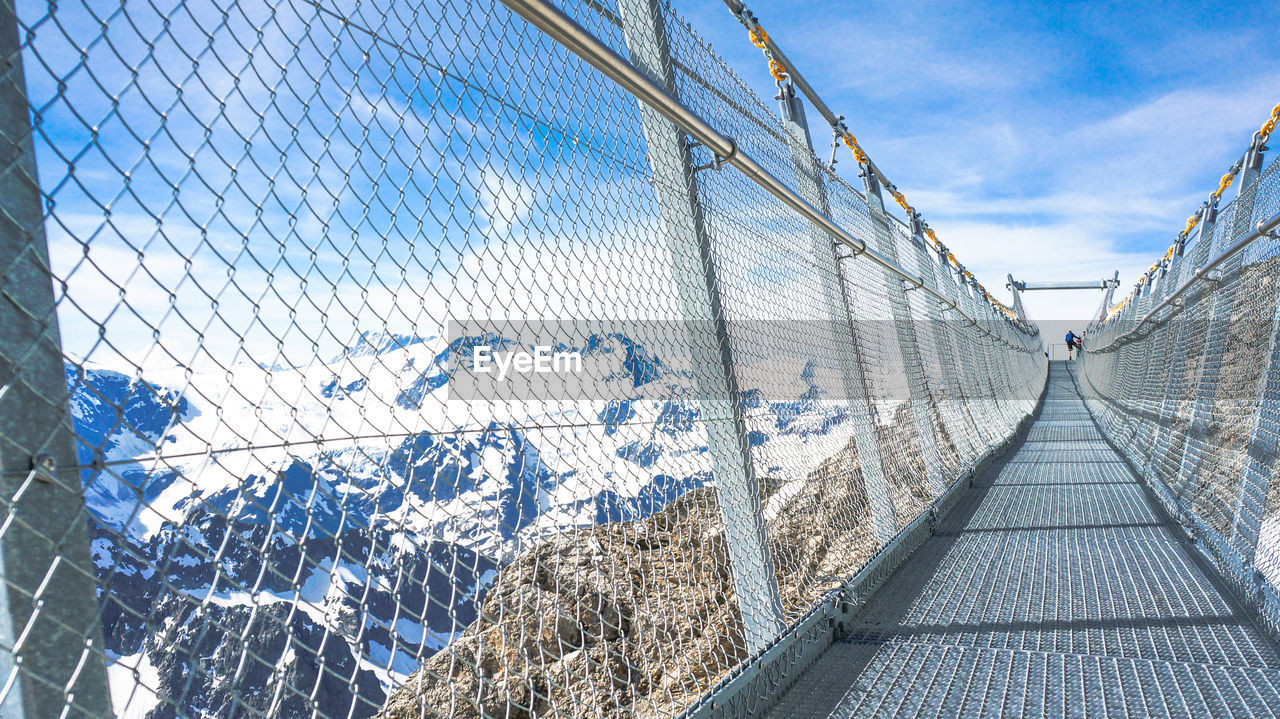 Empty titlis cliff walk by mountains against sky