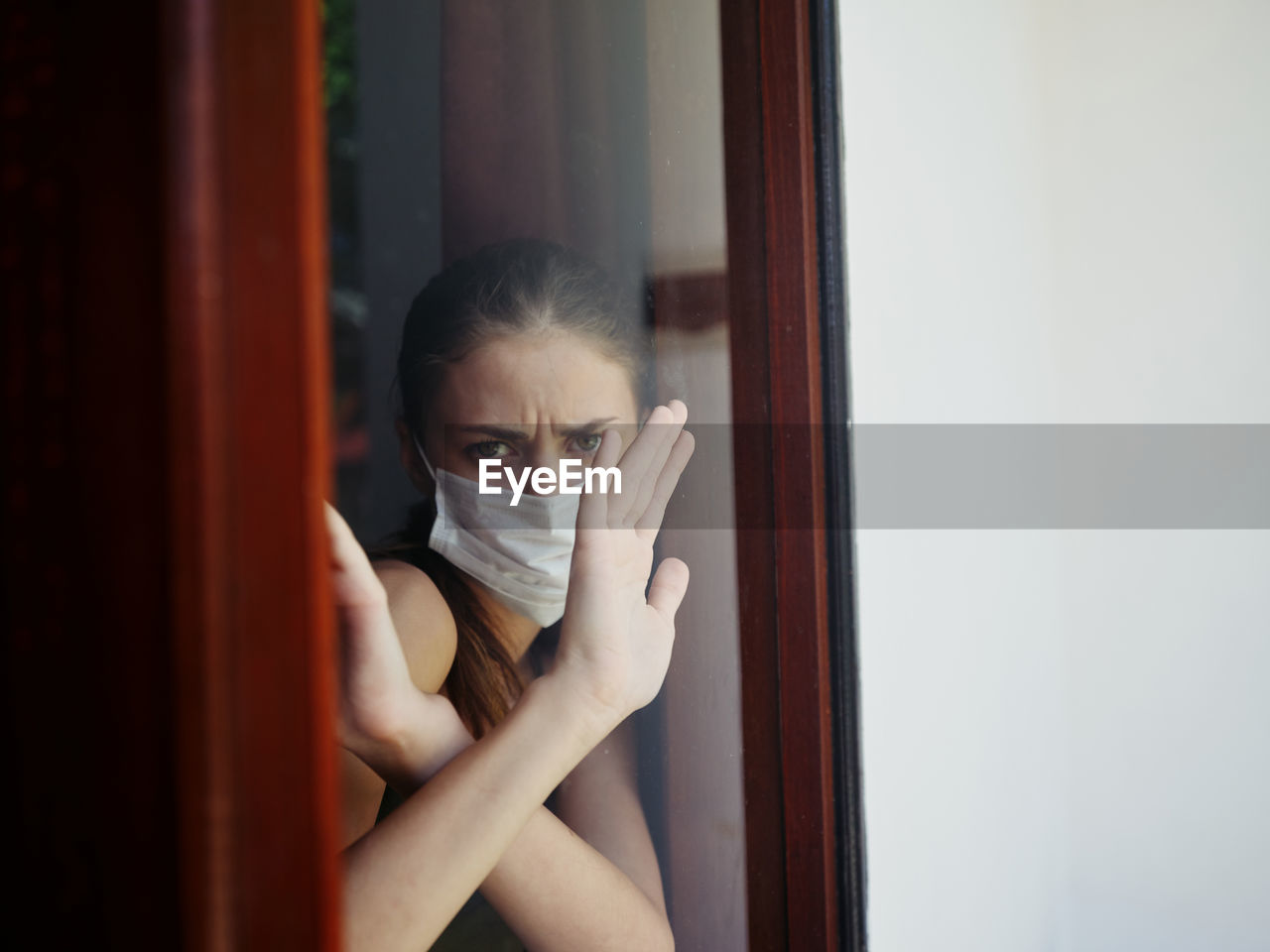 Portrait of young woman on window