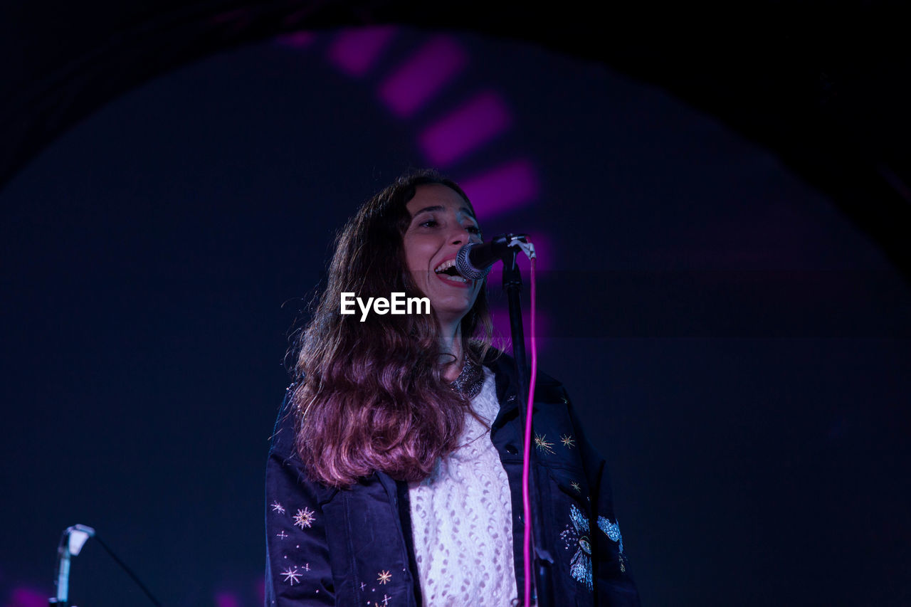 Low angle view of woman singing during concert