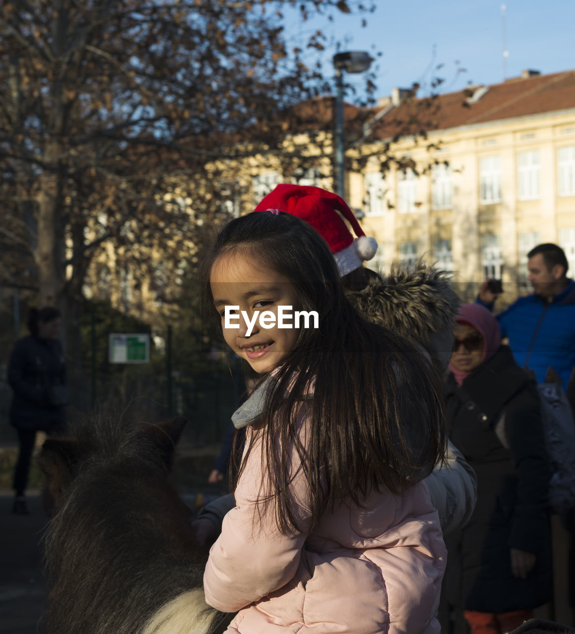 Portrait of girl riding pony on street in city