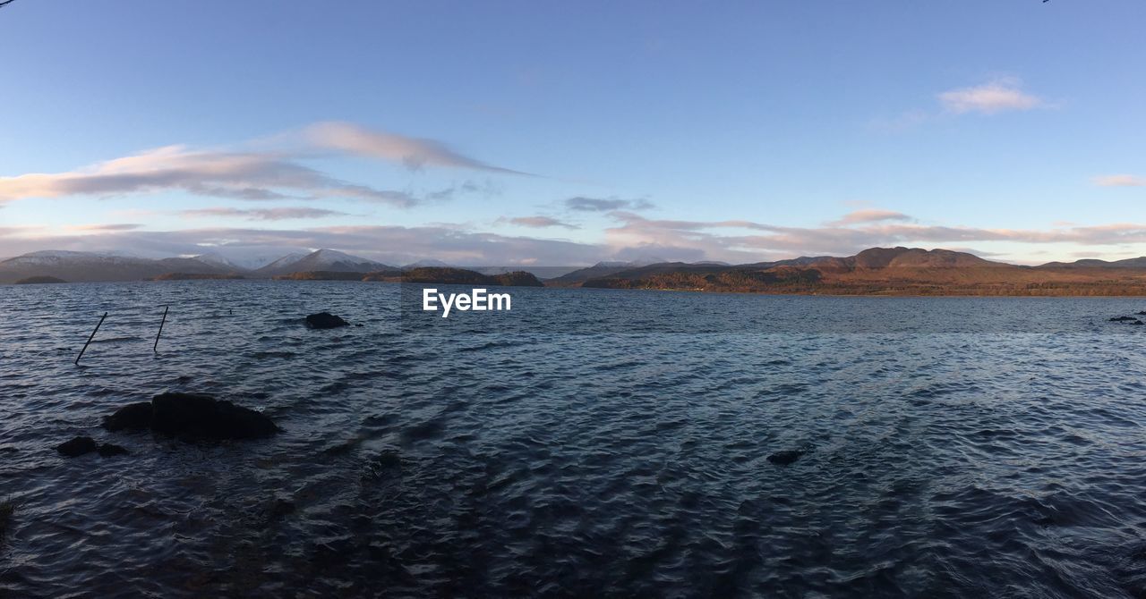 SCENIC VIEW OF LAKE BY MOUNTAINS AGAINST SKY