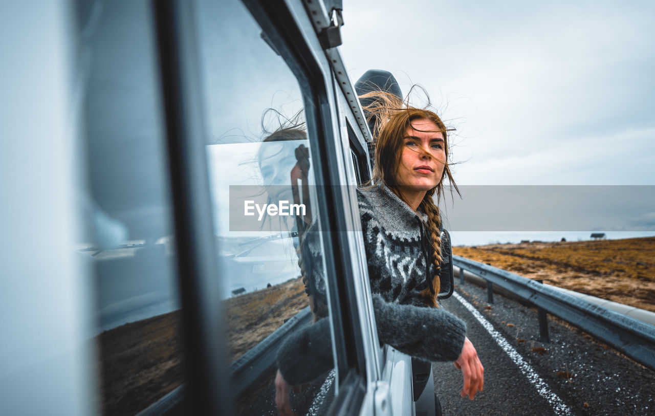 BEAUTIFUL WOMAN IN CAR AGAINST SKY