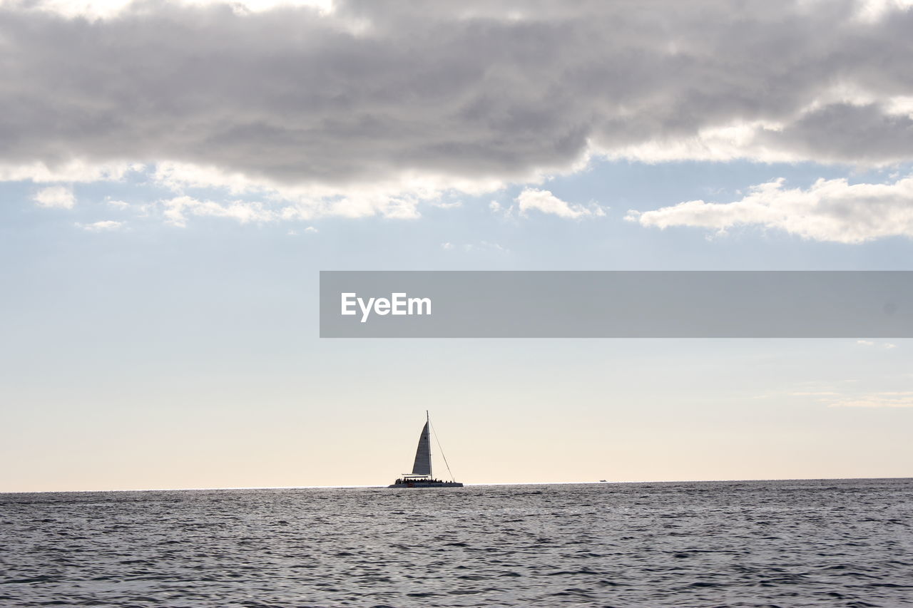 Sailboat sailing on sea against sky