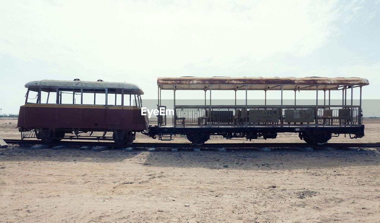 Old safari train on railroad track against sky