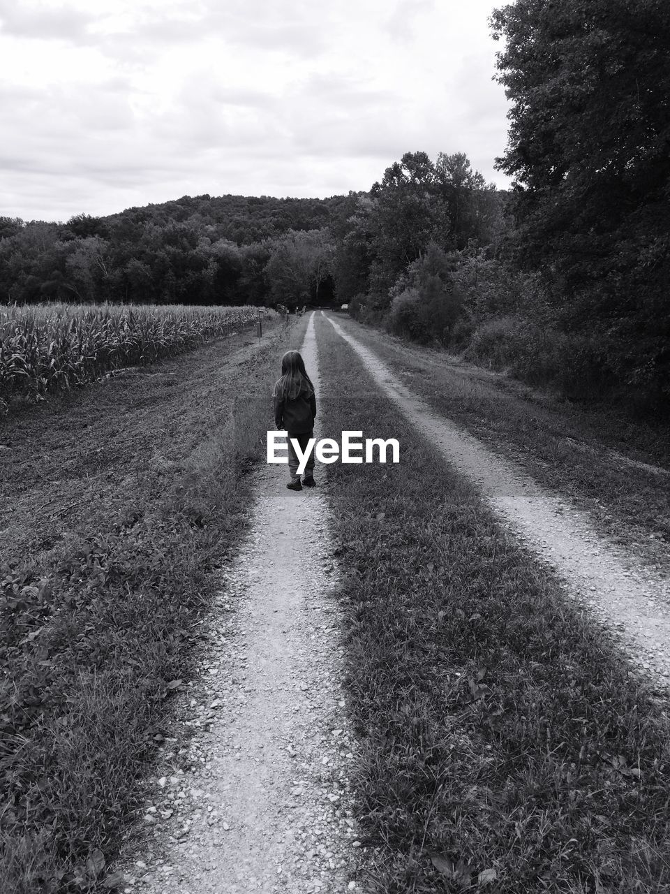 Child standing on a dirt road