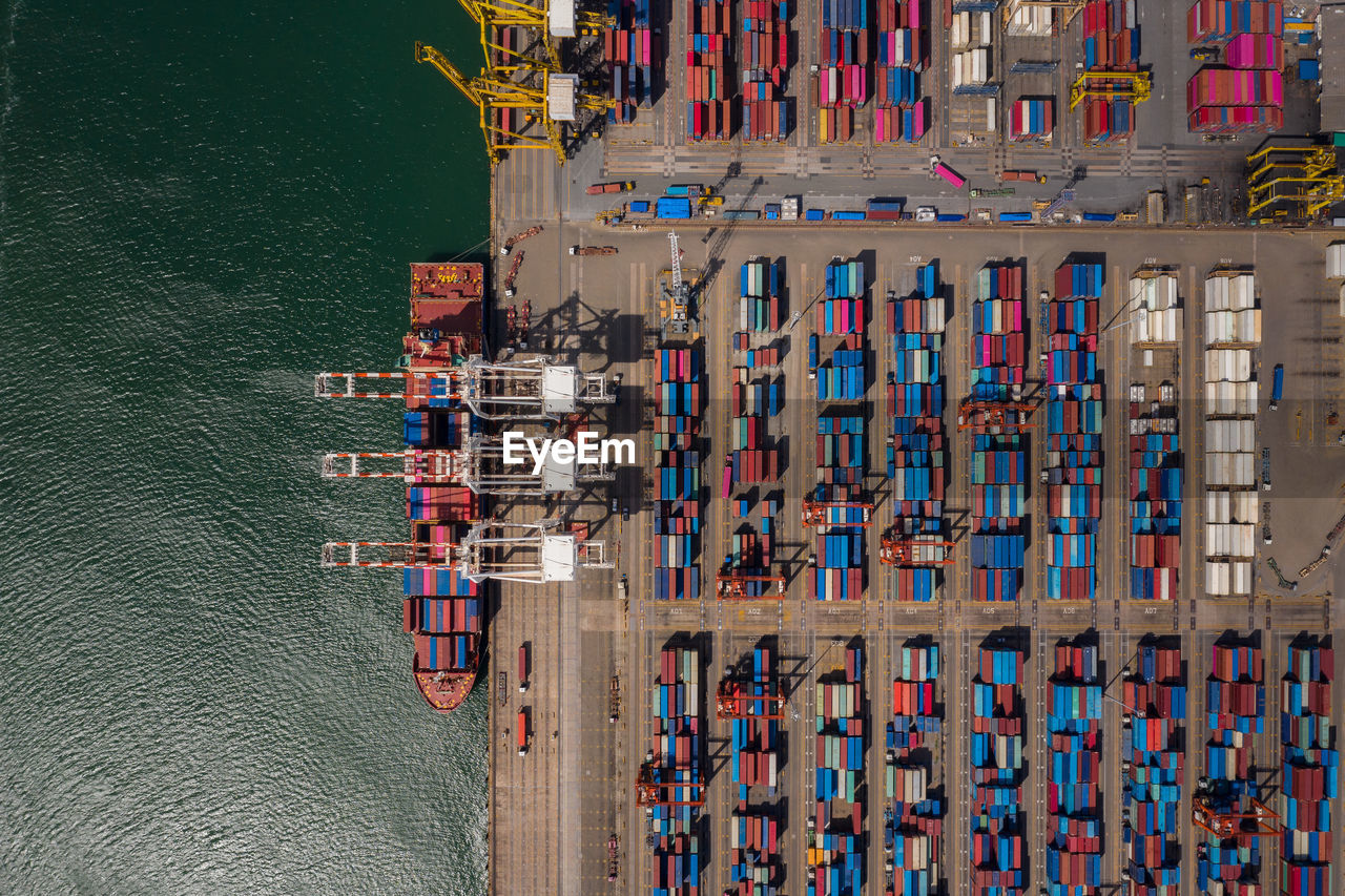 Container ship loading and unloading in sea port, aerial view of business logistic import and export 