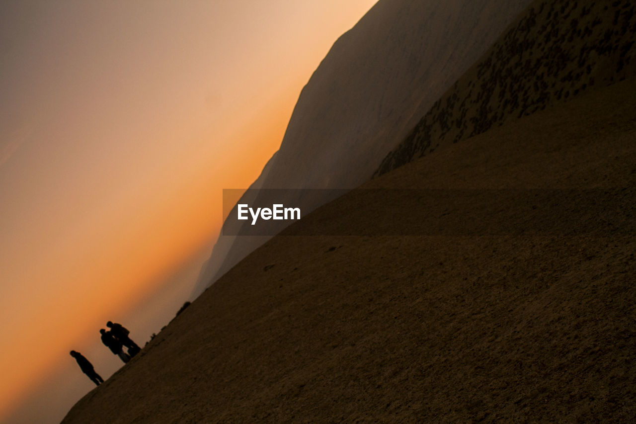 LOW ANGLE VIEW OF A MOUNTAIN AGAINST SKY DURING SUNSET