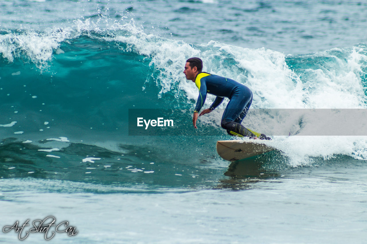 MAN SURFING ON SEA