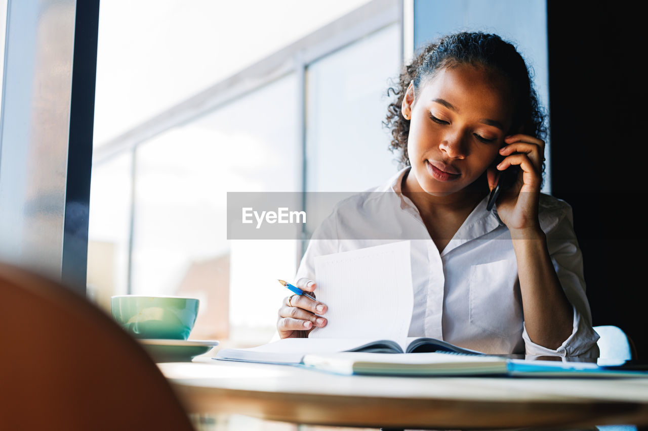 Businesswoman talking on mobile phone at office