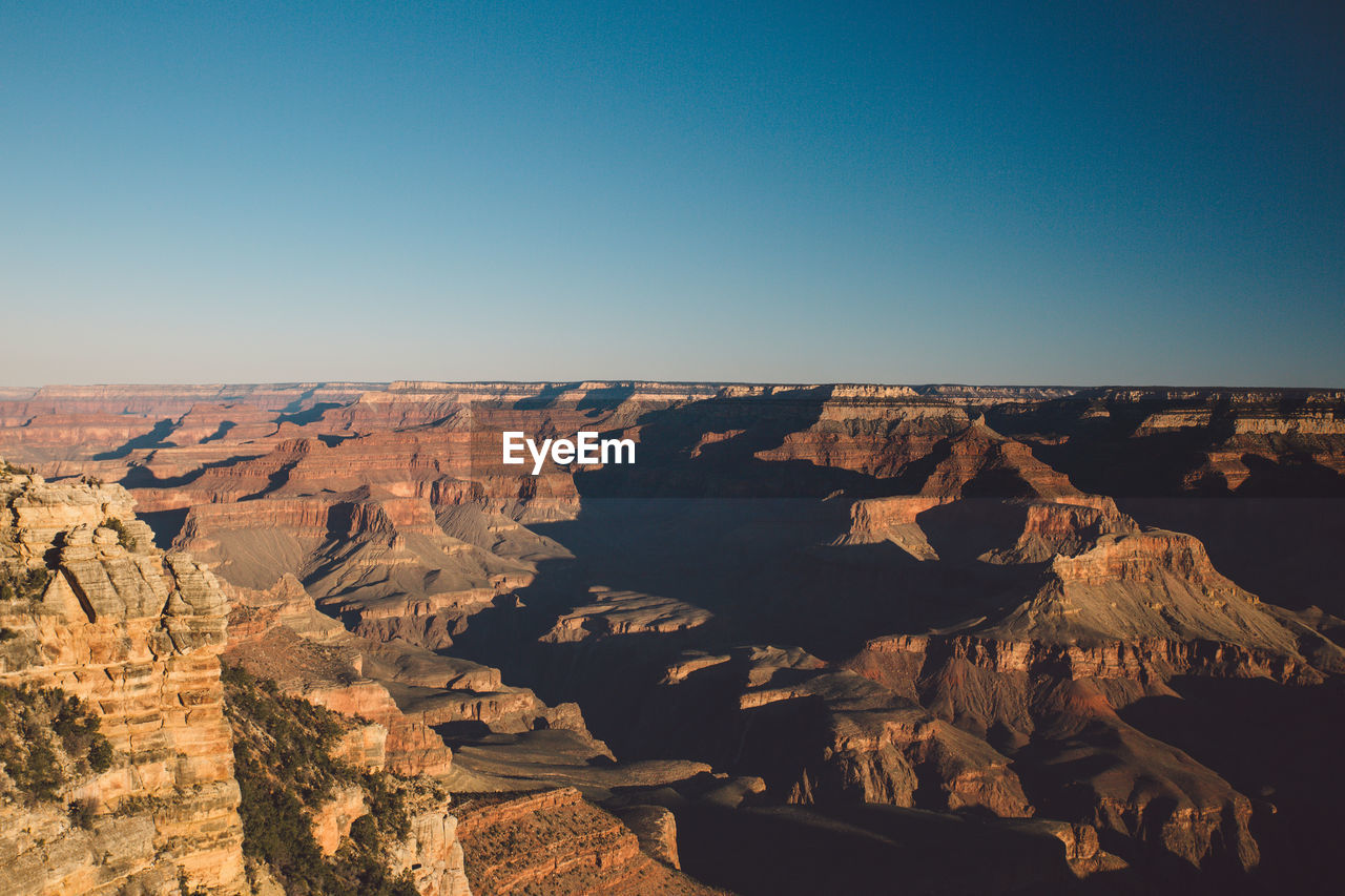 Aerial view of rock formations against clear blue sky