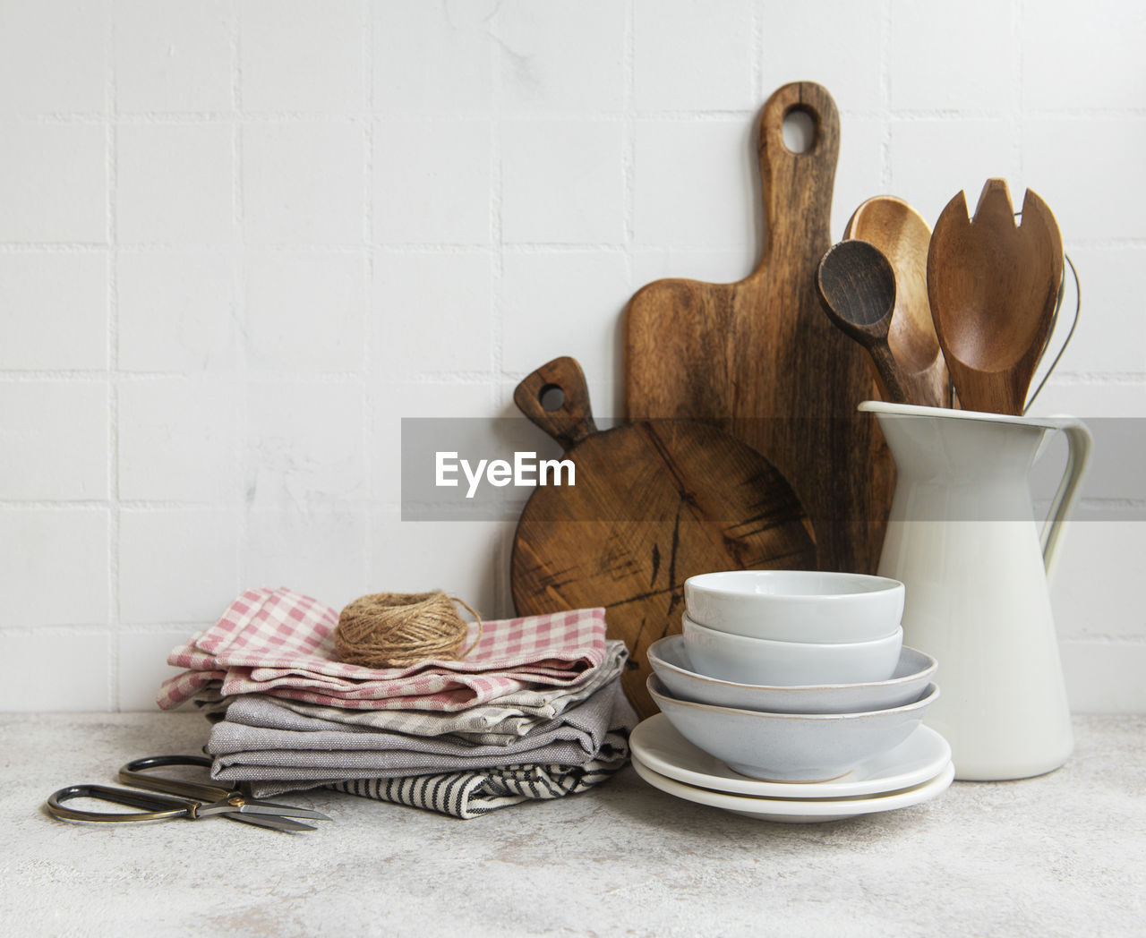 Kitchen utensils, tools and dishware on on the background white tile wall. 