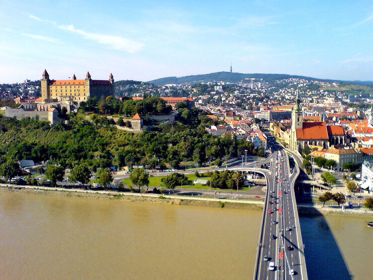 Multiple lane highway over river leading towards cityscape