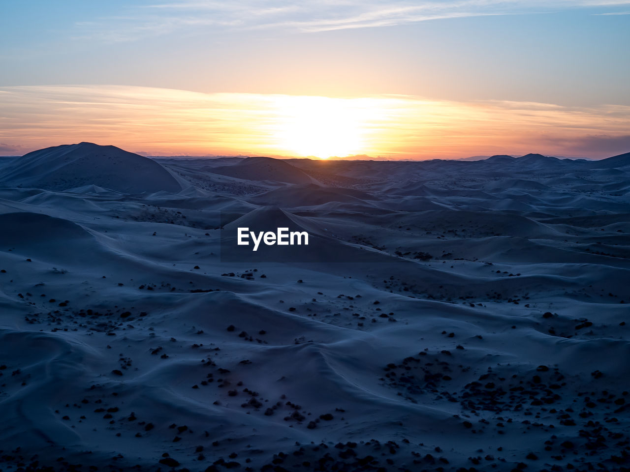 SCENIC VIEW OF SNOWCAPPED MOUNTAINS AGAINST ORANGE SKY