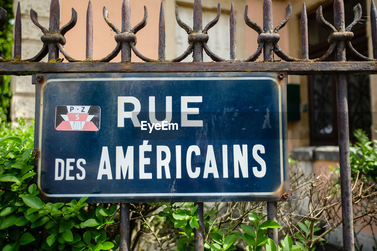 CLOSE-UP OF SIGNBOARD HANGING ON PLANT