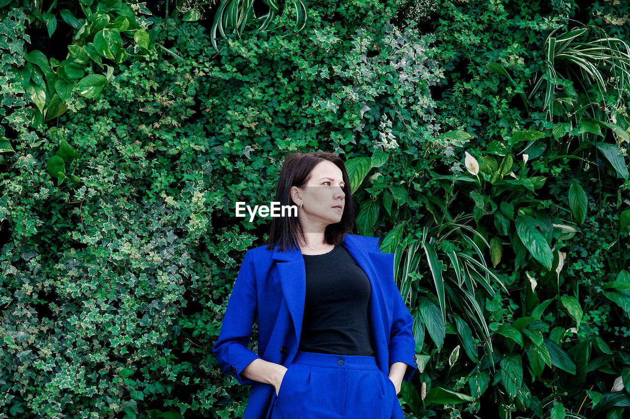 Woman standing against plants