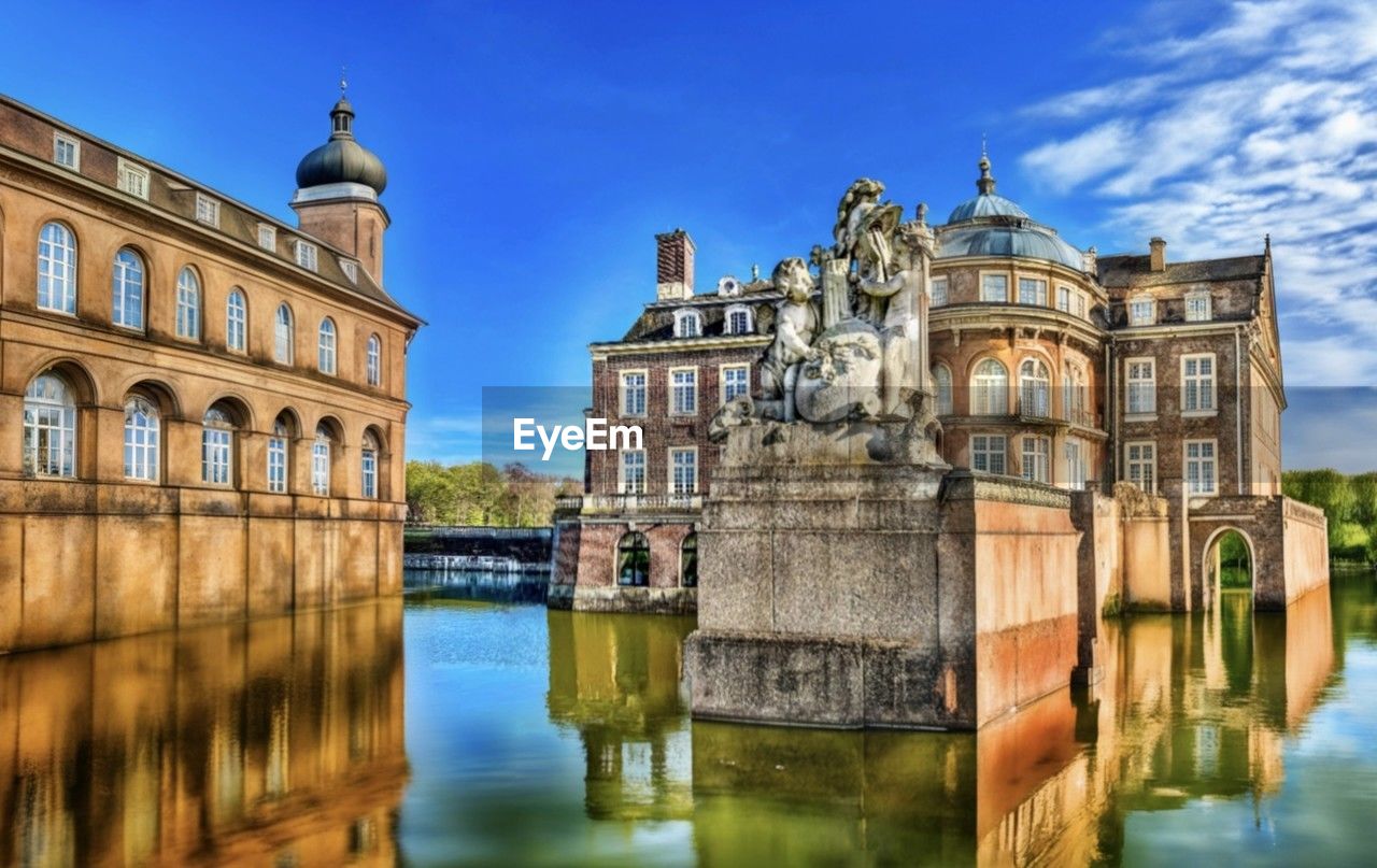 architecture, water, built structure, building exterior, landmark, travel destinations, reflection, sky, tourism, nature, waterway, cityscape, château, city, history, palace, travel, the past, building, river, town, blue, cloud, estate, no people, water castle, bridge, outdoors, moat, waterfront, day, old, tower, beauty in nature