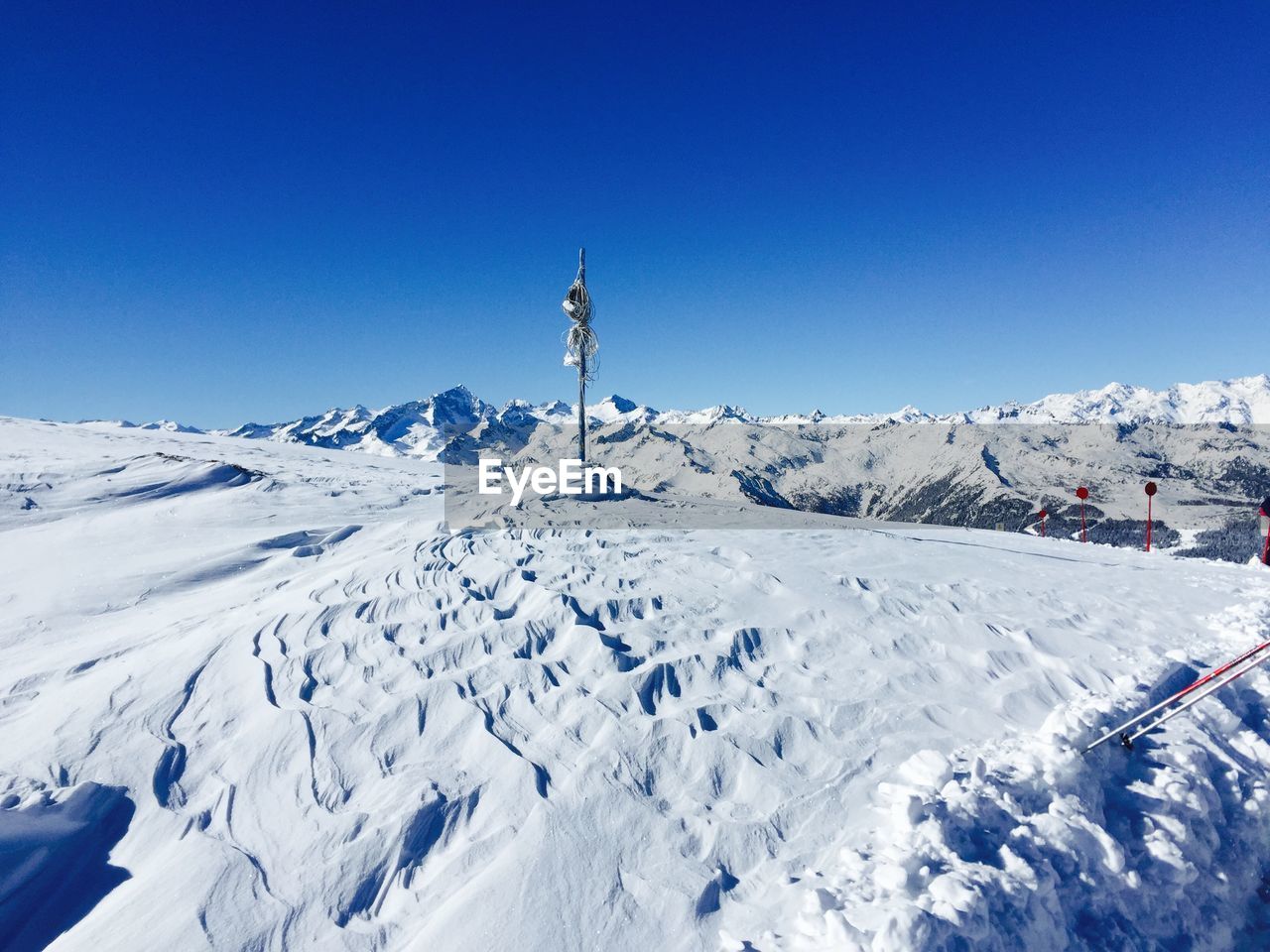 Scenic view of snowcapped mountains against blue sky on sunny day